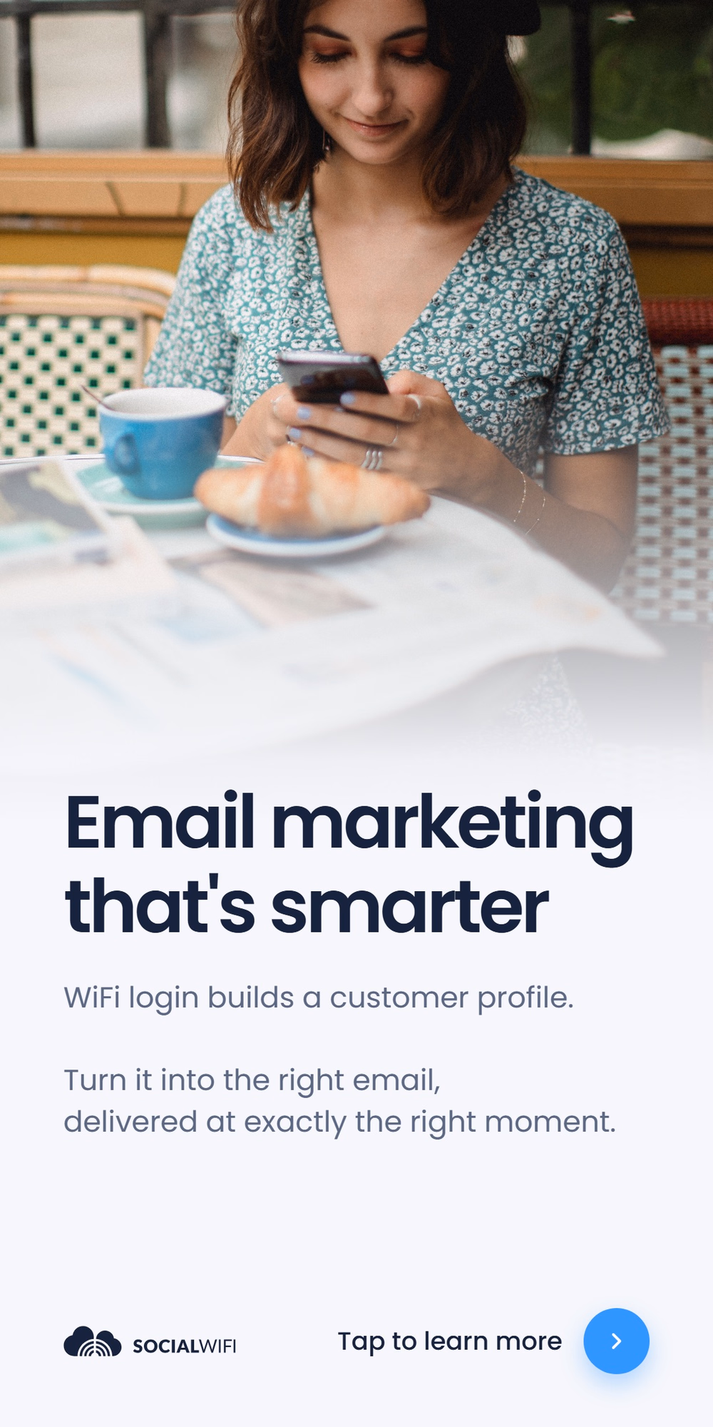 Guest relaxing at a cafe table with coffee and a croissant while checking her phone, next to the headline 'Email marketing that's smarter'