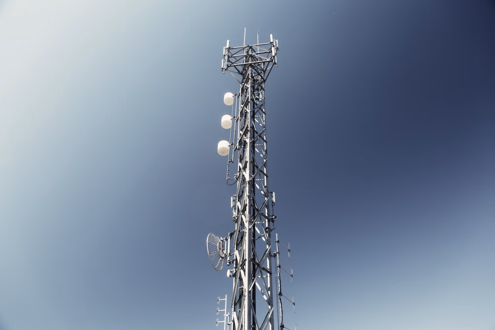 a signal tower in front of a blue sky
