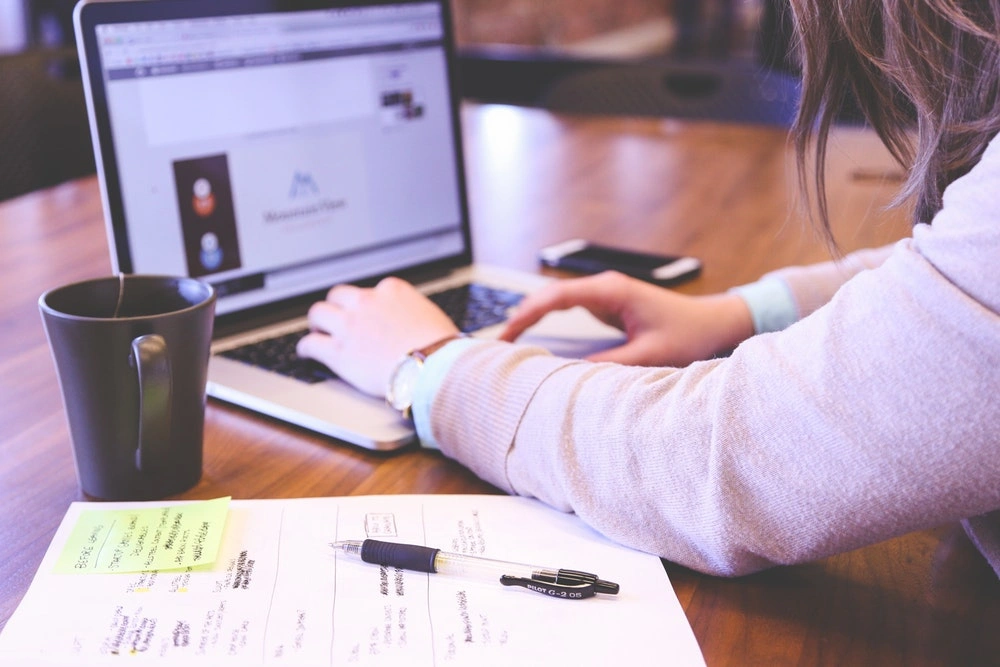 woman typing on a laptop presenting marketing content