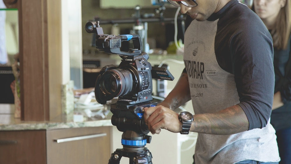 a man holding a camera on a tripod