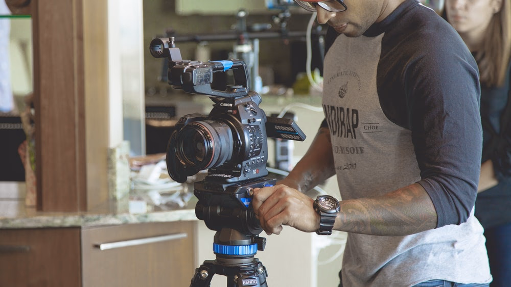 a man holding a camera on a tripod