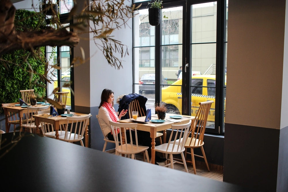 woman sitting in a restaurant with her phone out