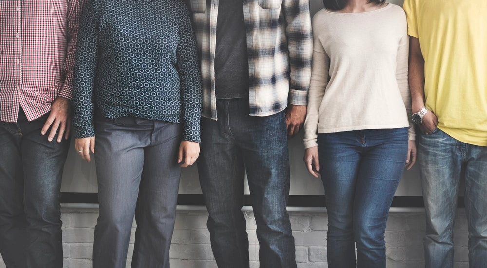 five people in various clothes standing next to each other