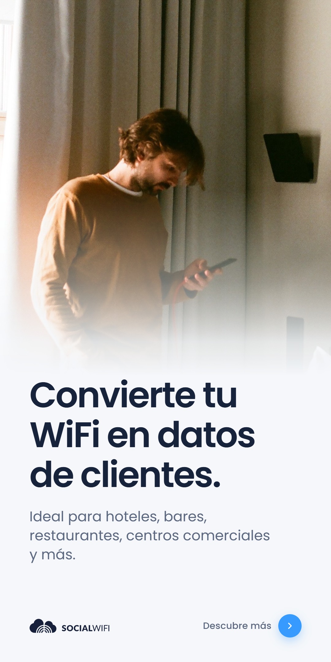Hombre revisando su teléfono junto a un punto de acceso WiFi montado en la pared, bajo el titular 'Convierte tu WiFi en datos de clientes' y el texto 'Ideal para hoteles, bares, restaurantes, centros comerciales y más'