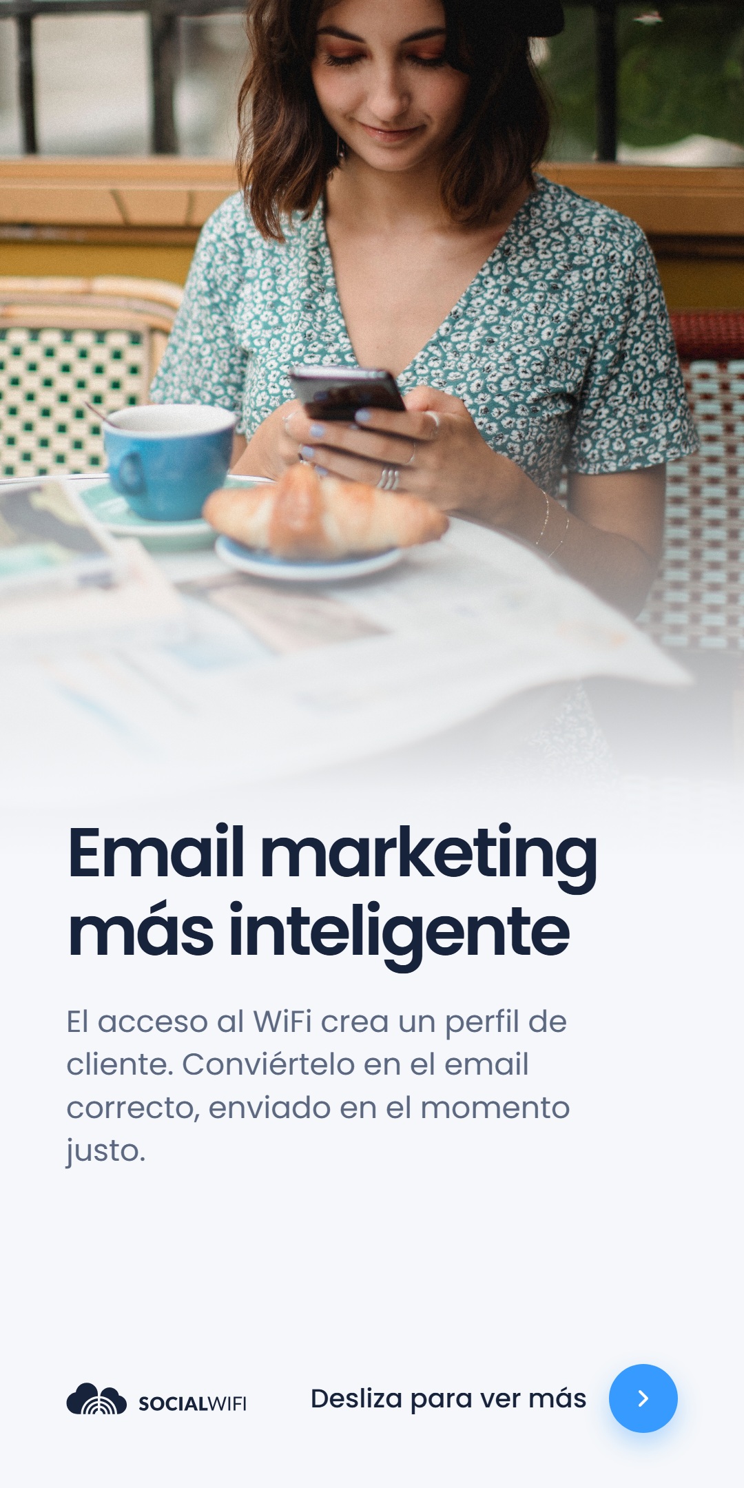 Mujer relajándose en una mesa de cafetería con café y un croissant, revisando su teléfono, junto al titular 'Email marketing más inteligente'